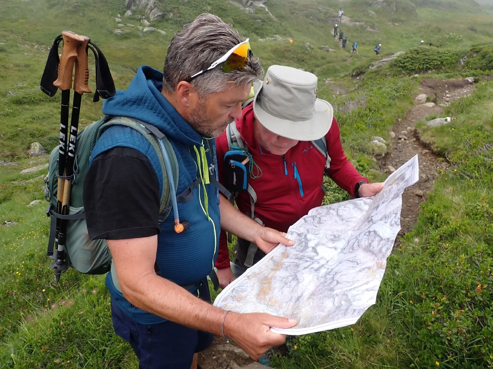 Wanderer über eine Landkarte gebeugt | © Eduard Koch