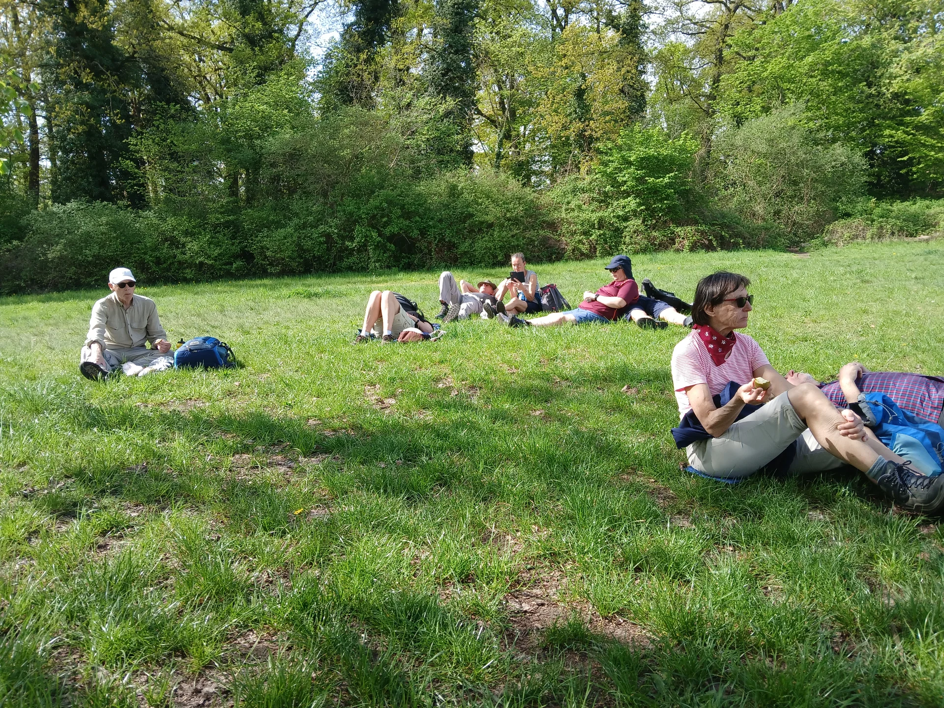 Fünf müde Wanderer bei einer Pause auf einer Rasenfläche im Park | © Gerhild Schiller