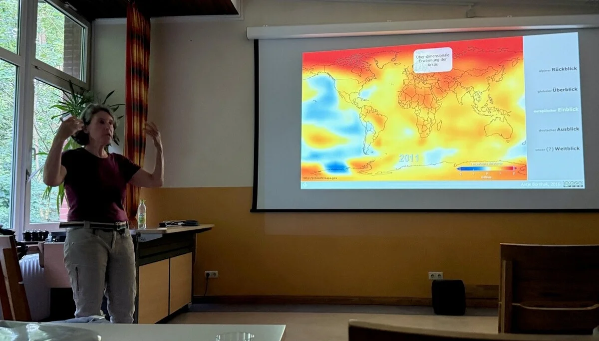 Eine Dozentin vor der Darstellung der Erderwärmung | © Gerhild Schiller