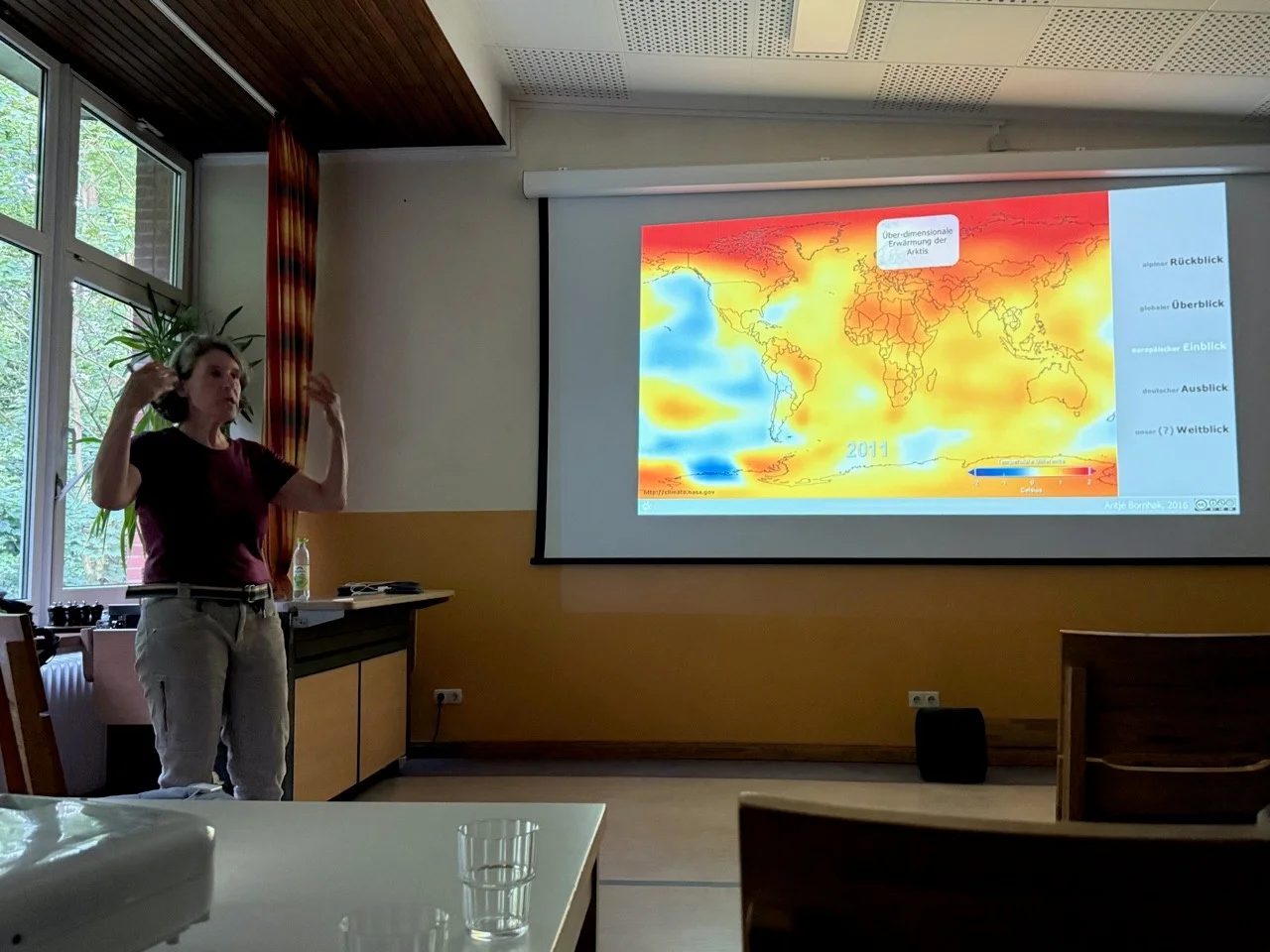 Eine Dozentin vor der Darstellung der Erderwärmung | © Gerhild Schiller