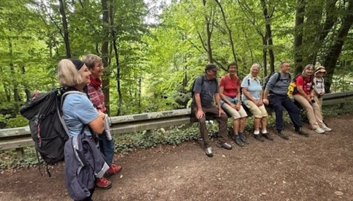 eine Gruppe Wanderer bei einer Pause auf einer Leitplanke sitzend | © Gerhild Schiller